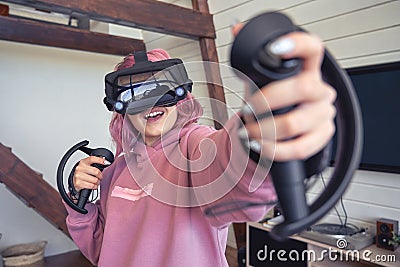 Excited teen hipster girl playing virtual reality video game wear vr goggles. Stock Photo