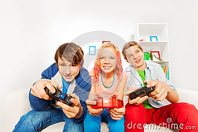 Excited teens hold joysticks and play game console Stock Photo