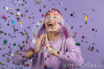 Excited unique woman clapping hands, having fun, screaming WOW, rejoices over confetti rain in studio. Extraordinary Stock Photo