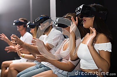 Excited woman is experiencing with friends virtual reality Stock Photo