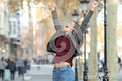 Excited woman jumping in the street Stock Photo