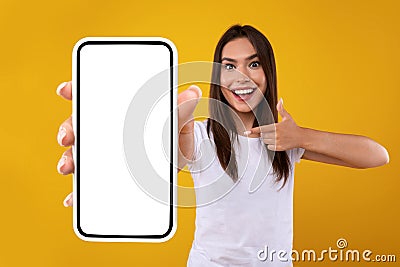 Excited woman pointing at white empty smartphone screen Stock Photo