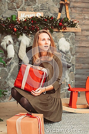 Excited woman with presents in Christmas interior Stock Photo