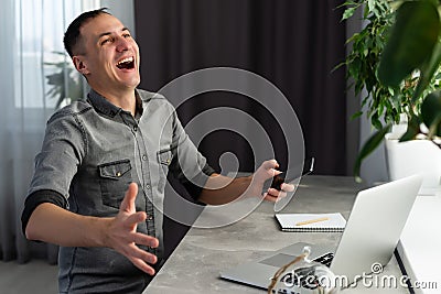 Excited worker sitting at desk in coworking space use computer reading message looking at device screen received great Stock Photo
