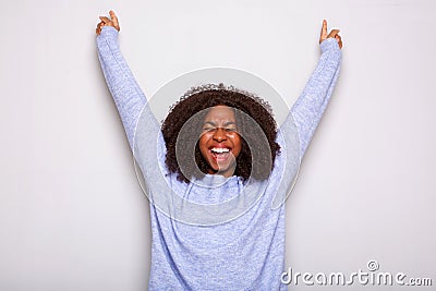 Excited young african american woman cheering with hands raised against white background Stock Photo