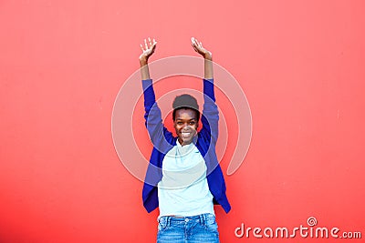 Excited young african woman standing with her arms raised Stock Photo