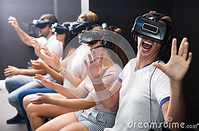 Excited man experiencing with friends virtual reality Stock Photo