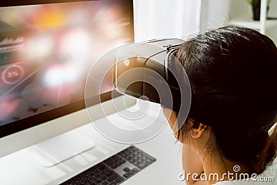 Excited young Asian woman using a virtual reality headset and joysticks, Concept connection and interfaces of digital technology. Stock Photo