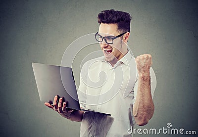 Excited man with laptop computer celebrating success Stock Photo