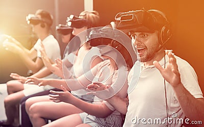 Excited man experiencing with friends virtual reality Stock Photo