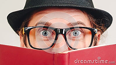 Excited young nerd guy holding book. Nerd in glasses. Funny man looking to camera. Never too late to study. Amazing man has great Stock Photo