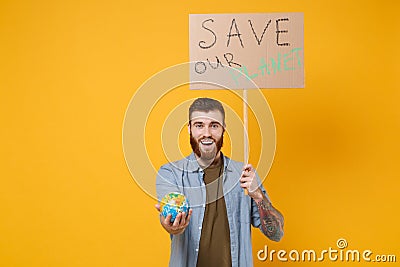 Excited young protesting man hold protest sign broadsheet placard on stick, Earth world globe isolated on yellow Stock Photo