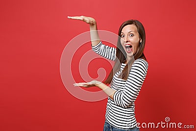 Excited young woman gesturing demonstrating size with copy space, keeping mouth wide open, looking surprised isolated on Stock Photo