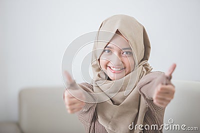 Excited young woman with hijab smiling to camera and showing thu Stock Photo