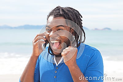 Exciting african american guy with dreadlocks at phone Stock Photo