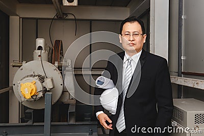 Executive engineer stand beside heavy machinery Stock Photo