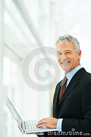 Executive, smile and laptop for working with technology in office with authority for budgets. Man, happiness and Stock Photo