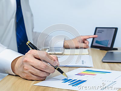 executive â€‹write on document data graph while using table Stock Photo