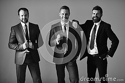 Executives advertise company and partnership on light grey background. Businessmen wear smart suits and ties. Business Stock Photo