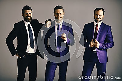 Executives advertise company and partnership on light grey background. Businessmen wear smart suits and ties. Business Stock Photo