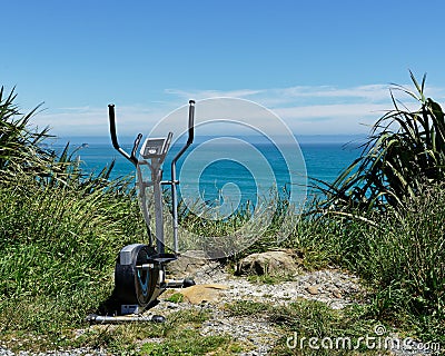 Exercise bike dumped in a layby overlooking the ocean, a gym with a view, west coast, south island, New Zealand Stock Photo