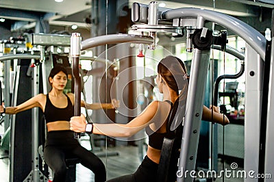 your arms with this arm exercise machine. healthy women exercise in fitness gym Stock Photo