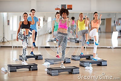 Exercisers with female instructor on group training Stock Photo