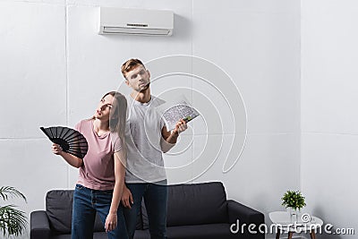 Exhausted couple with hand fan and Stock Photo