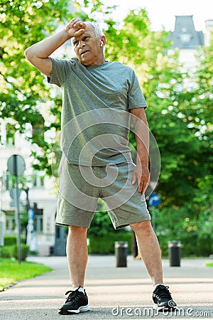 Exhausted elderly man after his jogging workout Stock Photo