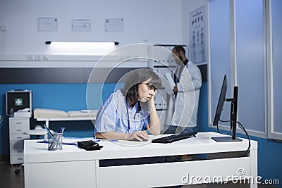 Exhausted female nurse in clinic office Stock Photo