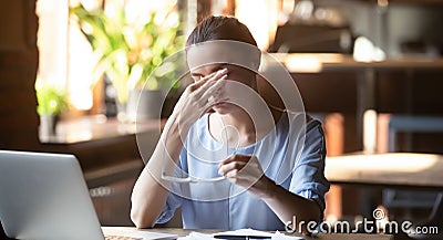 Exhausted female rubbing eyes suffering from blurry vision Stock Photo