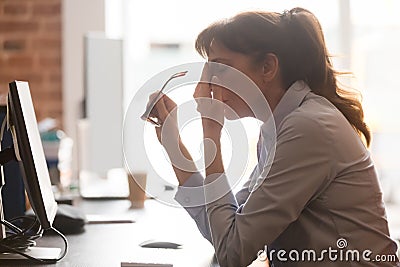 Tired female employee suffer from headache at workplace Stock Photo