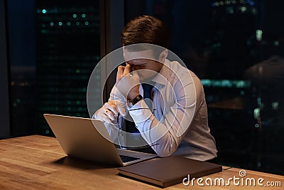 Exhausted male employee overwork late in office Stock Photo