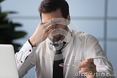 Exhausted male employee suffering from strong headache Stock Photo