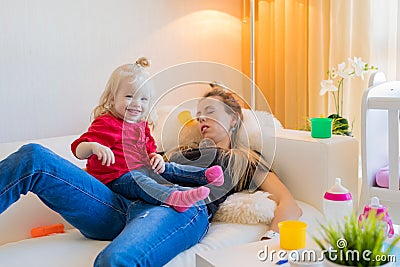 Exhausted mom fallen asleep on couch Stock Photo