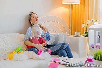 Exhausted mother fallen asleep in front of computer Stock Photo