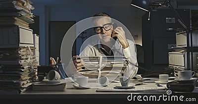 Exhausted office worker answering phone calls Stock Photo