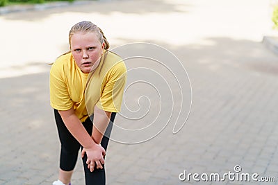 Exhausted overweight girl resting after intensive exercises. Stock Photo