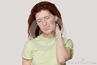 Tired red-haired girl massage neck suffering from spasm Stock Photo