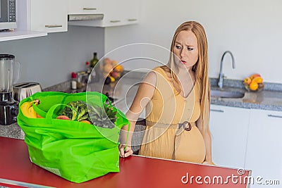 Exhausted but resilient, a pregnant woman feels fatigue after bringing home a sizable bag of groceries, showcasing her Stock Photo
