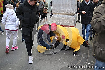 LONDON, UK - February 16, 2018: Exhausted street artist next to his fancy dress counting hard earned money, people walking and loo Editorial Stock Photo