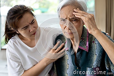 Exhausted tired asian senior woman touching head with her hands, ill elderly has vertigo,dizziness,sick old people suffering from Stock Photo