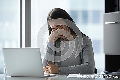 Exhausted tired young businesswoman massaging eyelids, feeling eyestrain Stock Photo