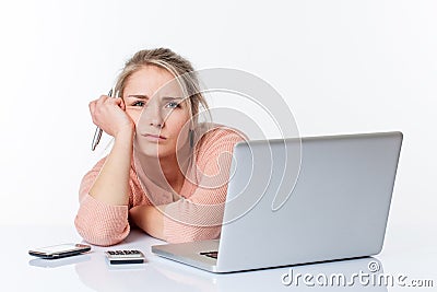 Exhausted unhappy blond girl leaning on her white sparse desk Stock Photo