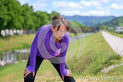 Exhausted woman jogger taking a break Stock Photo