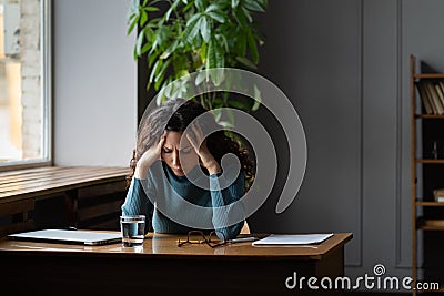 Exhausted woman sit at desk with closed laptop tired of overwork, burnout and lack of inspiration Stock Photo