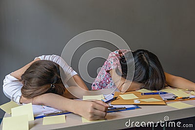Exhausted women sleeping on desk full of document Stock Photo