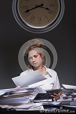 Exhausted worker doing paperwork Stock Photo