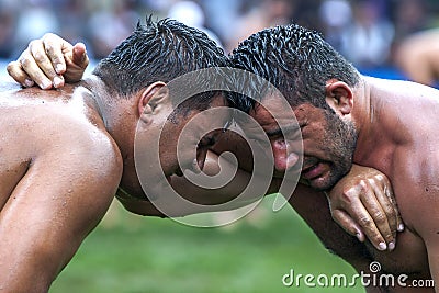 Exhausted wrestlers face each other at the Kemer Turkish Oil Wrestling Festival in Kemer in Turkey. Editorial Stock Photo