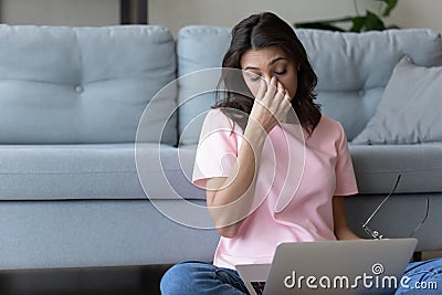 Exhausted young arabic indian woman taking off glasses. Stock Photo